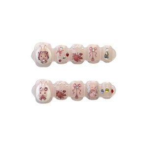 Faux ongles faits main motif lapin fraise avec nœuds 3D et strass sur fond blanc