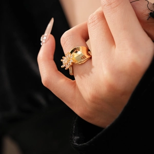 Macro detail of 18K gold plated flower ring with sparkling zircon stones on model's hand