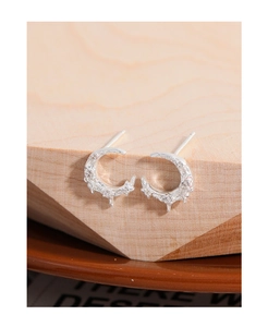 Detail of 925 sterling silver moon stud earring with lava texture on wooden block