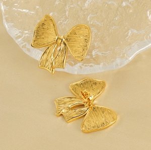 Gros plan sur les boucles d'oreilles nœud plaquées or 18 carats brossées