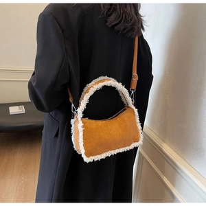 Detail of brown suede shoulder bag with white faux shearling trim and metal strap hooks