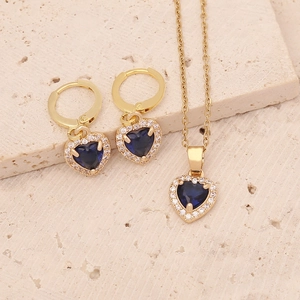 Detail of gold heart pendant and earrings set with dark blue zircon and micro-pave stones