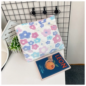 Detail shot of plush flower pattern bag texture on a desk with lifestyle props