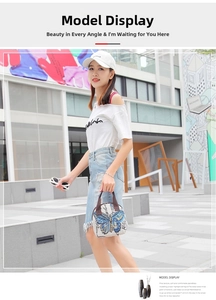 Ethnic style beige canvas handbag with blue butterfly print shown in a street style setting