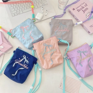 Draufsicht auf bunte Schultertaschen mit Schleifenstickerei in fünf Farben und Accessoires
