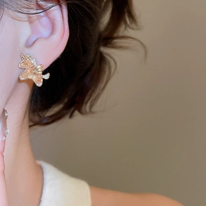 Close-up of a luxury unicorn stud earring with 18k gold plating and champagne crystals