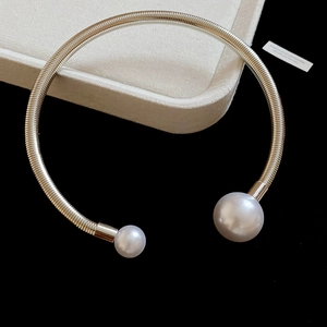 Detailed macro view of silver neck cuff with pearls and 925 silver hallmark engraving