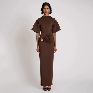 Détail d'une robe longue marron ajustée avec taille froncée, fente et boucle dorée