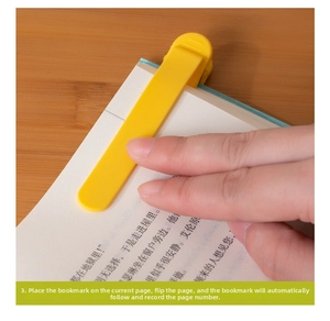 Close-up of yellow silicone bookmark automatically following pages on a wooden desk