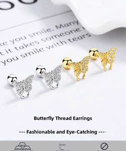 Macro shot of silver and gold butterfly screw back studs with sparkling zircon stones