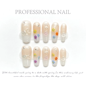 Detail of handmade press-on nails with 3D crystal hearts and floral art on gradient base