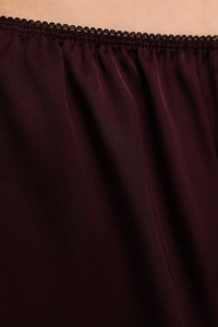 Detailed macro view of burgundy satin fabric with exquisite black lace trim and pleats