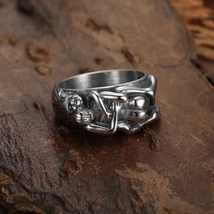 Punk-Ring aus Edelstahl mit detailliertem Totenkopf-Relief auf einem Holz-Hintergrund