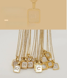 Détail de colliers carrés plaqués or 18K avec pendentifs alphabet en nacre évidés