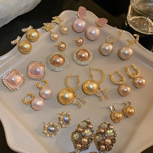 Flat lay of vintage pearl earrings with zircon inlay in gold and silver tones