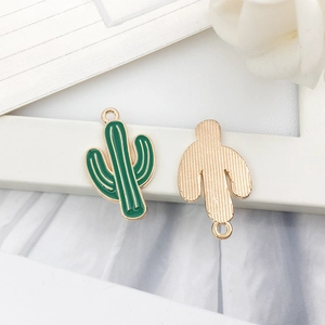 Macro detail of green enamel cactus alloy charms with golden metal back for DIY jewelry