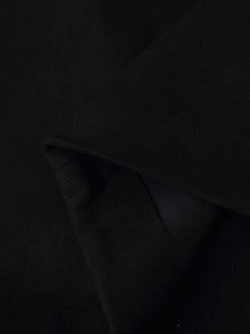 Gros plan macro du tissu noir d'un gilet ethnique montrant la texture tissée détaillée