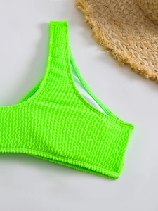 Detailed macro shot of neon green textured bikini top with wavy seersucker fabric finish
