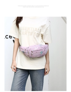 Détail du sac banane en nylon violet avec motifs graffiti colorés sur un modèle