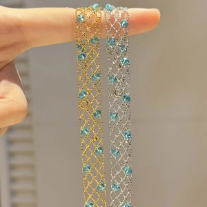 Close-up of fine metal mesh necklace with light blue gemstones in gold and silver