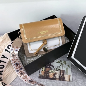 Brown and white colorblock crossbody bag in a black gift box with a wide strap
