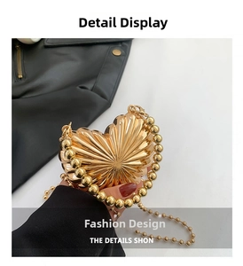 Detail of gold heart-shaped evening clutch bag with radial texture and beaded chain