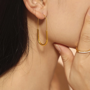 Minimalist gold U-shaped paperclip earrings and sparkling thin diamond eternity ring