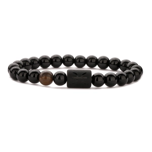 Macro shot of tiger eye stone and black agate beaded bracelet with zodiac symbol