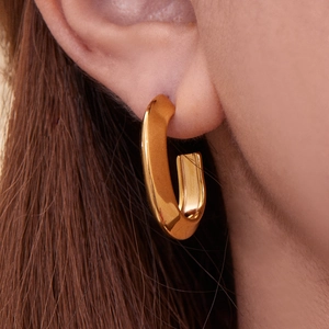 Polished 18k gold plated U-shaped grooved hoop earrings for women on a model