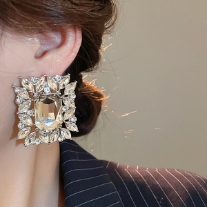 Close-up of elegant square crystal stud earrings with multiple sparkling leaf-shaped stones