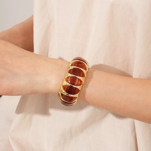 Detailed view of a vintage amber resin stretch bracelet with textured gold metal frames