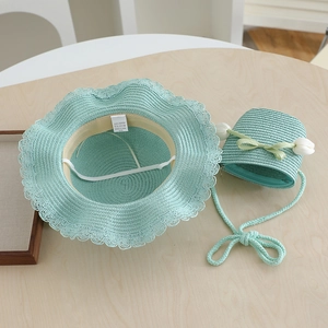 Detail of mint green woven straw hat and bag set with floral bow and 100% paper tag