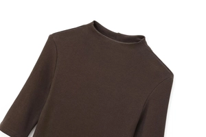 Detail of the high-neckline and rib-knit texture on a dark brown long-sleeve dress