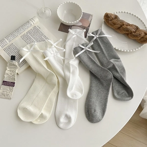 Detail of three colors ribbed knit crew socks with elegant white satin bow accents
