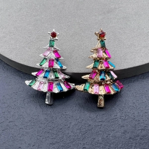 Detailed shot of gold and silver Christmas tree brooches with multi-colored crystals