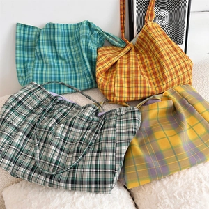 Detailed close-up showing checkered canvas tote bags in green, orange, black and yellow colors