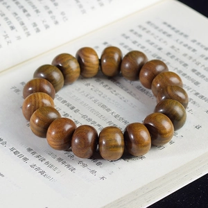 Vue détaillée de perles de bois de santal sur un livre montrant la texture du grain