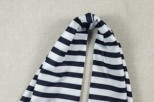 Macro detail of black and white striped fabric texture and stitching on a jumpsuit