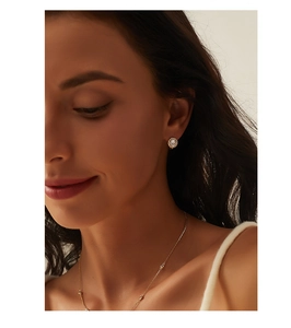 Gros plan élégant de boucles d'oreilles et collier en argent S925 plaqué or 14K avec zircons