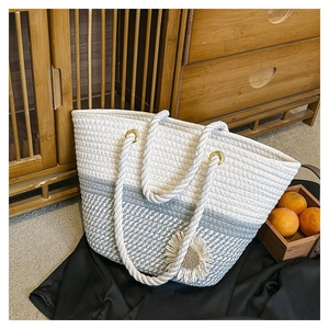 Detail of woven tote bag featuring blue and white textures with a sunflower ornament