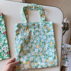 Close-up of floral cotton tote bag with a vintage metal snap button closure