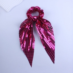 Detail of fuchsia sequin scrunchie with long ribbons and shimmering metallic finish