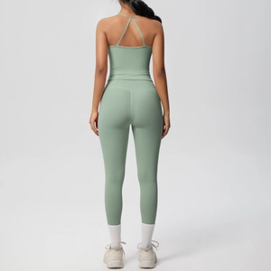 Detail of sage green yoga set showing cross-back sports bra and high-waisted leggings