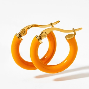 Detail of bright orange enamel coating on polished gold-plated stainless steel hoop earrings