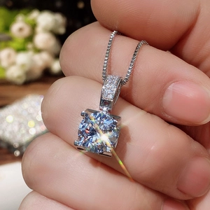 Classic silver-tone necklace featuring a square-cut solitaire diamond pendant held in hand