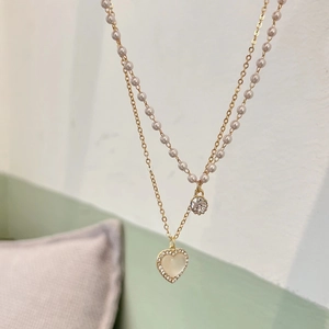 Double-layered gold chain necklace with pink pearls and heart rhinestone pendant