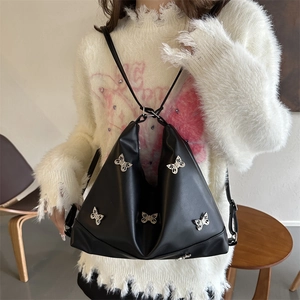Borsa tote vintage in pelle PU nera con fibbie a farfalla argentate indossata
