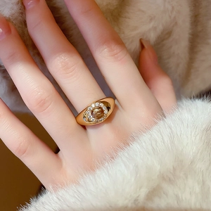 Macro view of gold-plated ring featuring tiger eye stone and zircon accents on hand