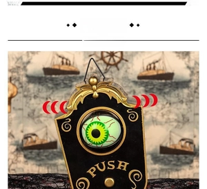 Macro shot of Halloween doorbell with glowing green eyeball and ornate golden details