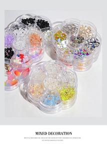 Mixed nail art charms including aurora bows, pearls, and rhinestones in a floral organizer